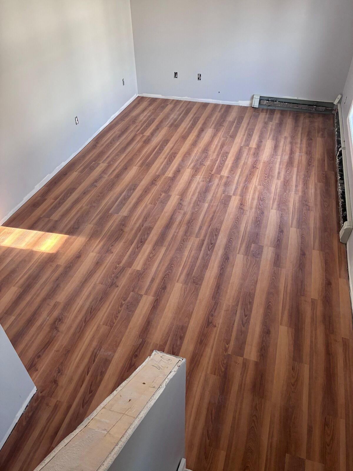 Finished warm wood-look flooring installation by Cordeiro Flooring