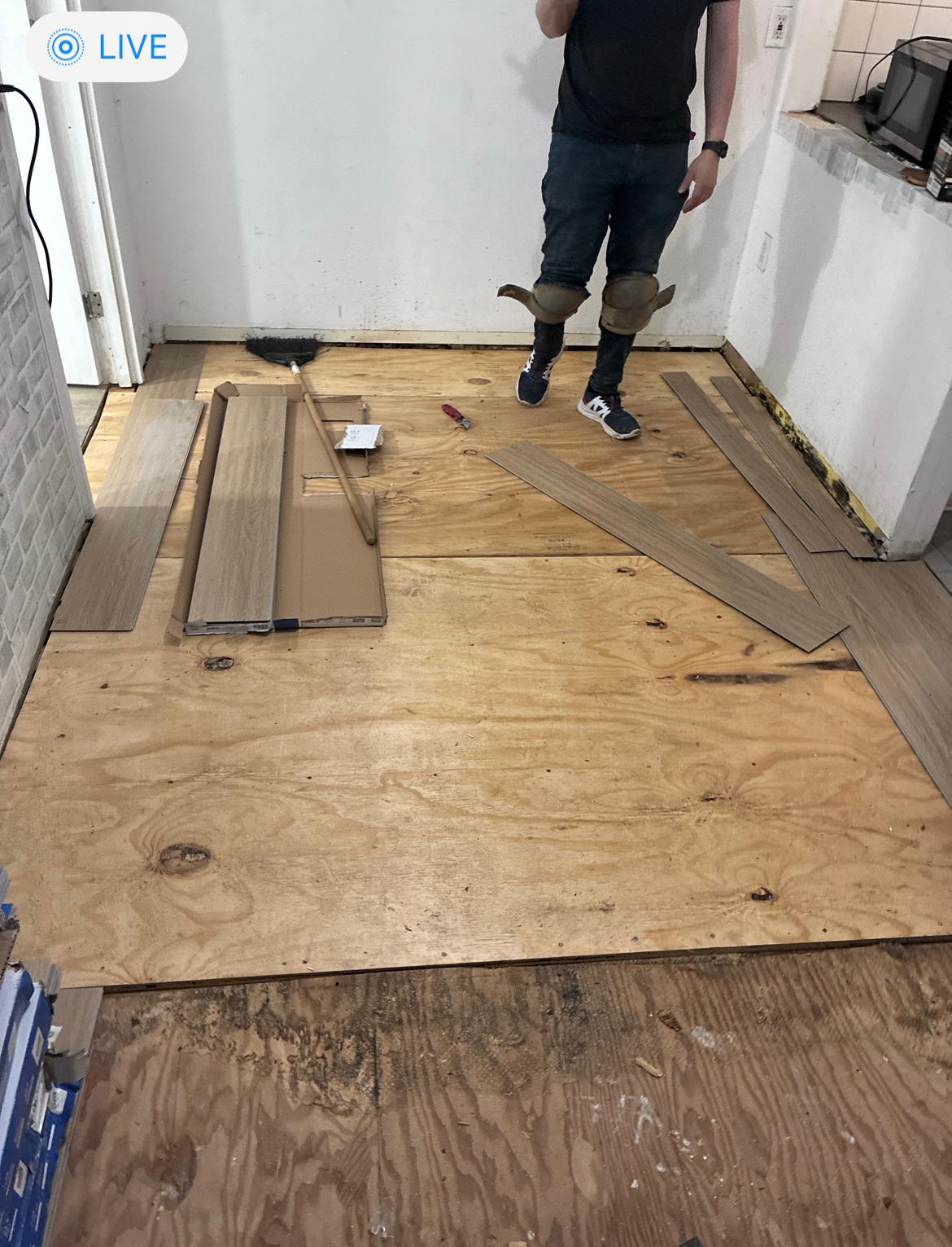 Plywood subfloor preparation with vinyl plank installation in progress